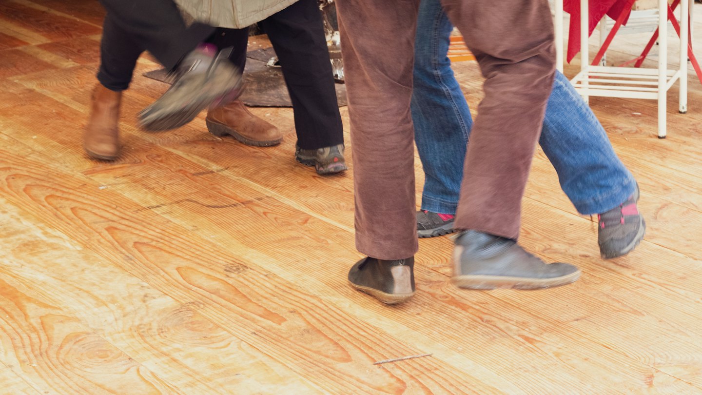 Gente bailando sobre un cálido suelo de madera.
